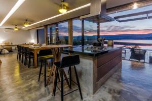 una cucina con un bancone e un tavolo con sedie di @morro.redondo - A casa no Lago e na Serra a CÃ¡ssia