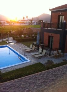 a backyard with a swimming pool and a house at Kalloni Beach Villas in Skala Kallonis