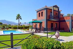 a house with a bird standing in front of it at Kalloni Beach Villas in Skala Kallonis