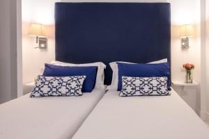 ein Bett mit blauen und weißen Kissen darauf in der Unterkunft SorrentoVibes - Luxury Apartment with Garden and Pool in Sant'Agnello + 26 Fotos