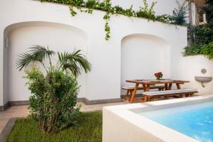 eine Terrasse mit Tisch und Swimmingpool in der Unterkunft SorrentoVibes - Luxury Apartment with Garden and Pool in Sant'Agnello