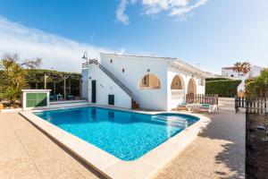 a swimming pool in front of a house at Casa Blanca - villa con piscina a 30m del mar-Binibeca in Sant Lluis