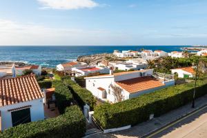 a view of a town with the ocean at Casa Blanca - villa con piscina a 30m del mar-Binibeca in Sant Lluis