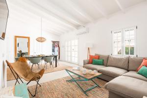 a living room with a couch and a table at Casa Blanca - villa con piscina a 30m del mar-Binibeca in Sant Lluis