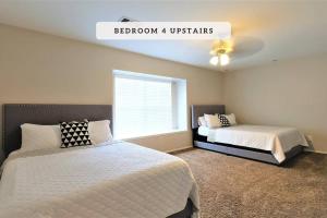 a bedroom with two beds and a window at Katy, GRAND TEXAS SIZE HOUSE, 6 Bedrooms 14 Beds - Sedgecreek in Katy