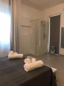 two towels on a bed in a bathroom with a shower at " DOMUS CORALLA" BnB Racconti Di Viaggio in Catania