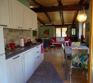 a kitchen with white cabinets and a table in a room at la finestra sul Monviso in Crissolo