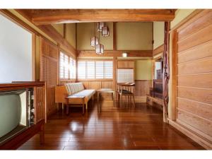 uma sala de estar com um sofá e uma televisão em Kayabuki Kominka Syuzenji - Vacation STAY 18448v em Izu