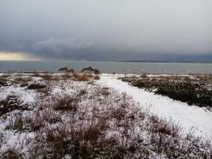 a snow covered field with houses and the ocean at Thealassa in Kalliópi