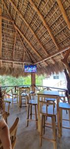 un grupo de mesas y sillas bajo un techo de paja en The Beach Break Hotel, en El Zonte