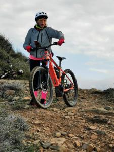 un hombre de pie junto a una bicicleta en una colina en Le Bozze "Il Leccino" con piscina, WI-FI, posto auto, en Castagneto Carducci