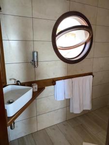 a bathroom with a sink and a mirror and towels at Romantic Beach House Vipingo in Vipingo