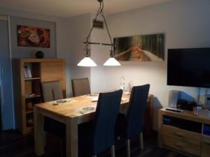 a dining room with a wooden table and blue chairs at Ferienwohnung Wolf in Ensdorf
