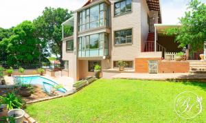 a large house with a yard and a swimming pool at Roseland House Self Catering in Durban