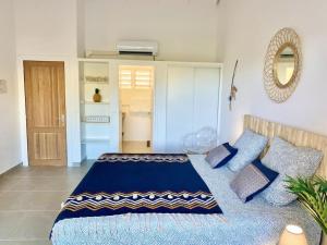 um quarto com uma cama azul com almofadas azuis em Beautiful suite S19 with pool and sea view em Cul de Sac