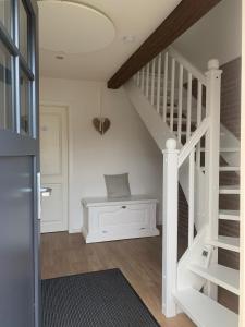 a white staircase with a bench in a room at Charmantes Haus mit zwei Ferienwohnungen und großem Garten in Aventoft - Enjoy! in Aventoft