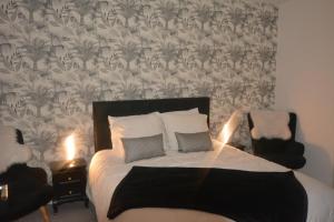 a bedroom with a bed with a black and white wallpaper at CHAMBRE D’HÔTES NATURE ET SAVEURS in Boutenac