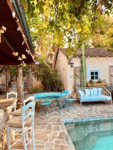 ロサンゼルスにあるUnder the Tuscan Sun Cottage in West Los Angelesのプールサイドのパティオ(テーブル、椅子付)