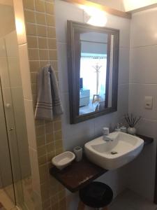 a bathroom with a sink and a mirror and a shower at Suite Independente Por do Sol Ferradura in Búzios