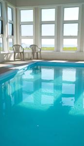 a swimming pool with two chairs and blue water at Château Madelinot in Fatima