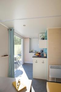 cocina y sala de estar con barra y mesa en Camping Campo Di Liccia, en Bonifacio