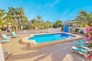 a swimming pool in a backyard with palm trees at Paula-3 - holiday home with private swimming pool in Moraira in Moraira