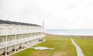 een gebouw met een grasveld naast de oceaan bij Château Madelinot in Fatima