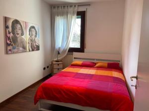 1 dormitorio con 1 cama con una manta colorida en Appartamento Girasole tra Padova e Venezia, en Fiesso dʼArtico
