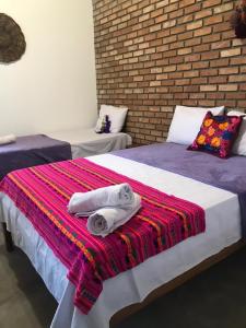 two beds with towels on them in a room at Pousada Pico Da Vila in Vale do Capao