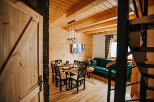 a living room with a green couch and a table at Holickie Berdo in Polańczyk