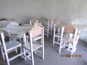 um grupo de mesas e cadeiras numa sala em Libibing chalets em Mokhotlong