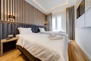 a hotel room with two beds and a television at Apart Compliment in Podgorica