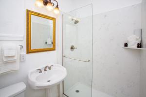 a white bathroom with a sink and a shower at MarQueen Hotel in Seattle