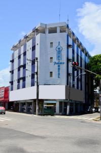- un grand bâtiment blanc avec un panneau bleu dans l'établissement Natal Palace Hotel, à Natal