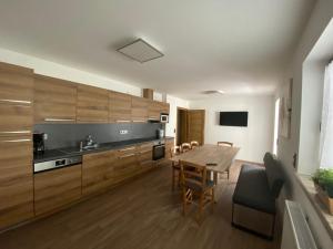 eine Küche mit Holzschränken sowie einem Tisch und Stühlen in der Unterkunft Pension Marina in Tux
