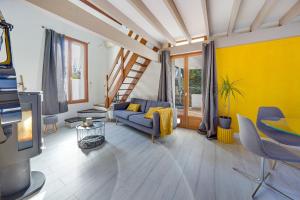 a living room with a blue couch and a yellow wall at Bel appart pour 6 p, clim, parking et terrasse in Aix-en-Provence