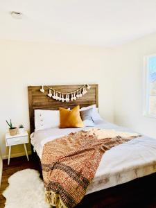 a bedroom with a bed with a wooden headboard at Casa Agave: Comfy Joshua Tree Cottage With Free Breakfast Bar in Joshua Tree