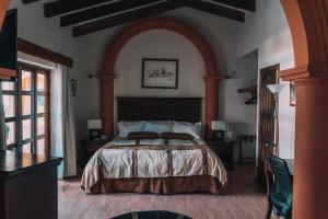 a bedroom with a large bed with an archway at Hotel Casa Mexicana in San Cristóbal de Las Casas