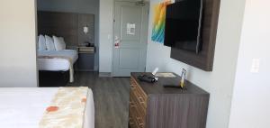 een hotelkamer met een bed en een flatscreen-tv bij Hawthorn Suites by Wyndham Panama City Beach FL in Panama City Beach