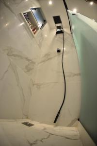 La salle de bains blanche est pourvue d'une douche avec un fil noir. dans l'établissement Apartamento Quarto e sala luxo COPACABANA O MUST', à Rio de Janeiro