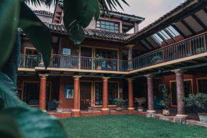 a house with columns and balconies and a yard at Hotel Casa Mexicana in San Cristóbal de Las Casas +35 photos