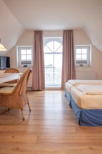 a hotel room with two beds and a desk at Baltrumer Teestube in Baltrum