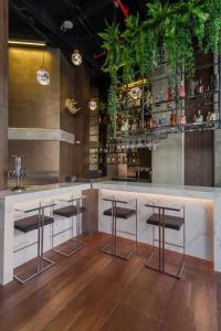 a bar with two stools and a counter with plants at VPV Suites in Medellín