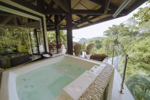 uma banheira de hidromassagem no deque de uma villa em Tulemar Resort em Manuel Antonio