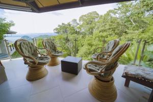 a row of chairs sitting next to each other on a patio at Tulemar Resort in Manuel Antonio