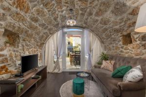 a living room with a stone wall at Apartments Mikulin Family in Punat
