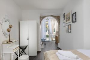 a bedroom with white walls and a bed and a hallway at Apartments Mikulin Family in Punat