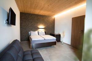 a bedroom with a bed and a couch in a room at Motel Q in Rottweil