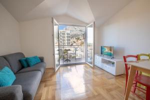 Beach Spot Apartments في ماكارسكا: غرفة معيشة مع أريكة وطاولة