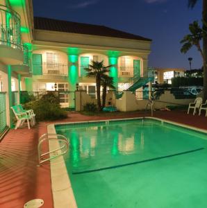 a swimming pool in front of a house at night at LYFE INN & SUITES by AGA - LAX Airport in Inglewood